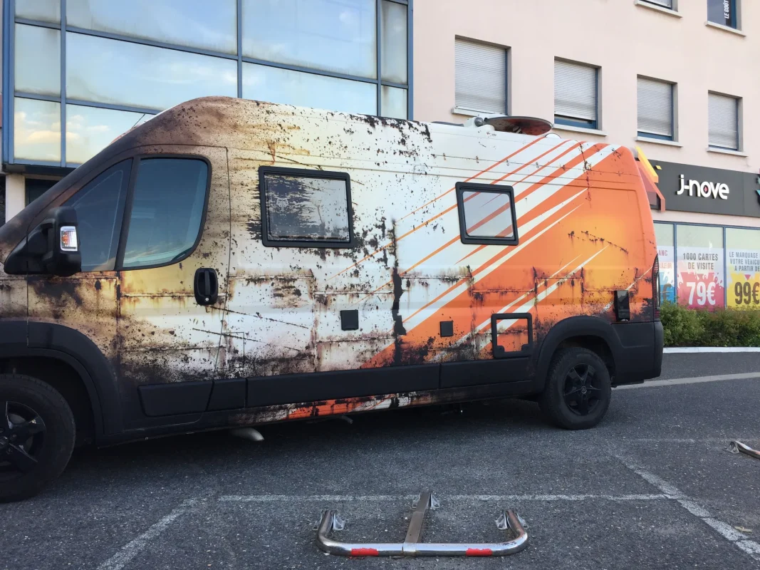 Fourgon habillé effet rouille garé devant la boutique J-NOVE.