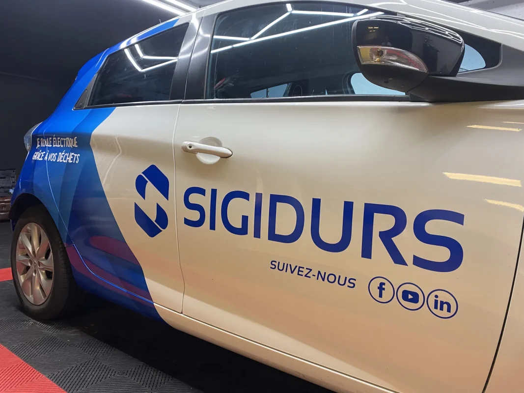 Citadine électrique habillée en covering bleu et blanc pour Sigidurs, vue de côté.